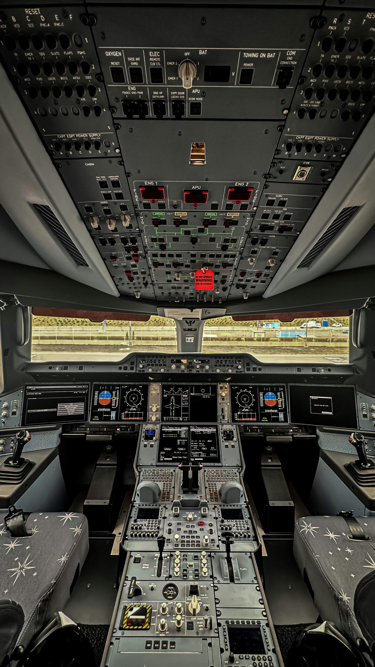 Detailed view of a modern airliner cockpit's instrument panels and control systems.